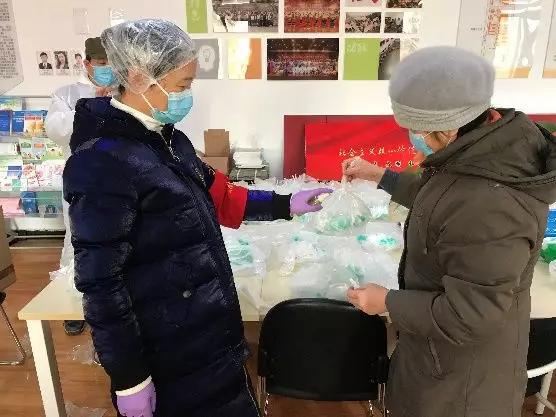為樓棟分發(fā)口罩，并為包裝袋消毒